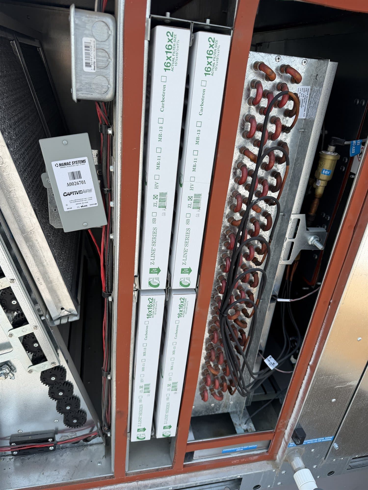 Rooftop unit opened for maintenance with new air filters and evaporator coil