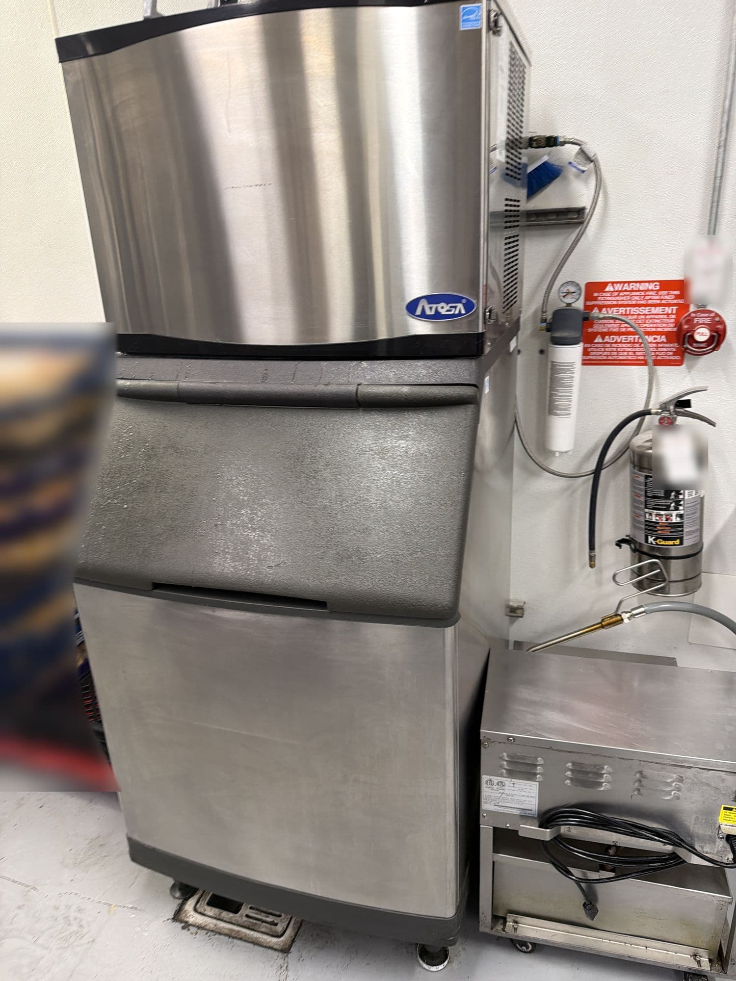 Commercial ice machine head sitting on a storage bin