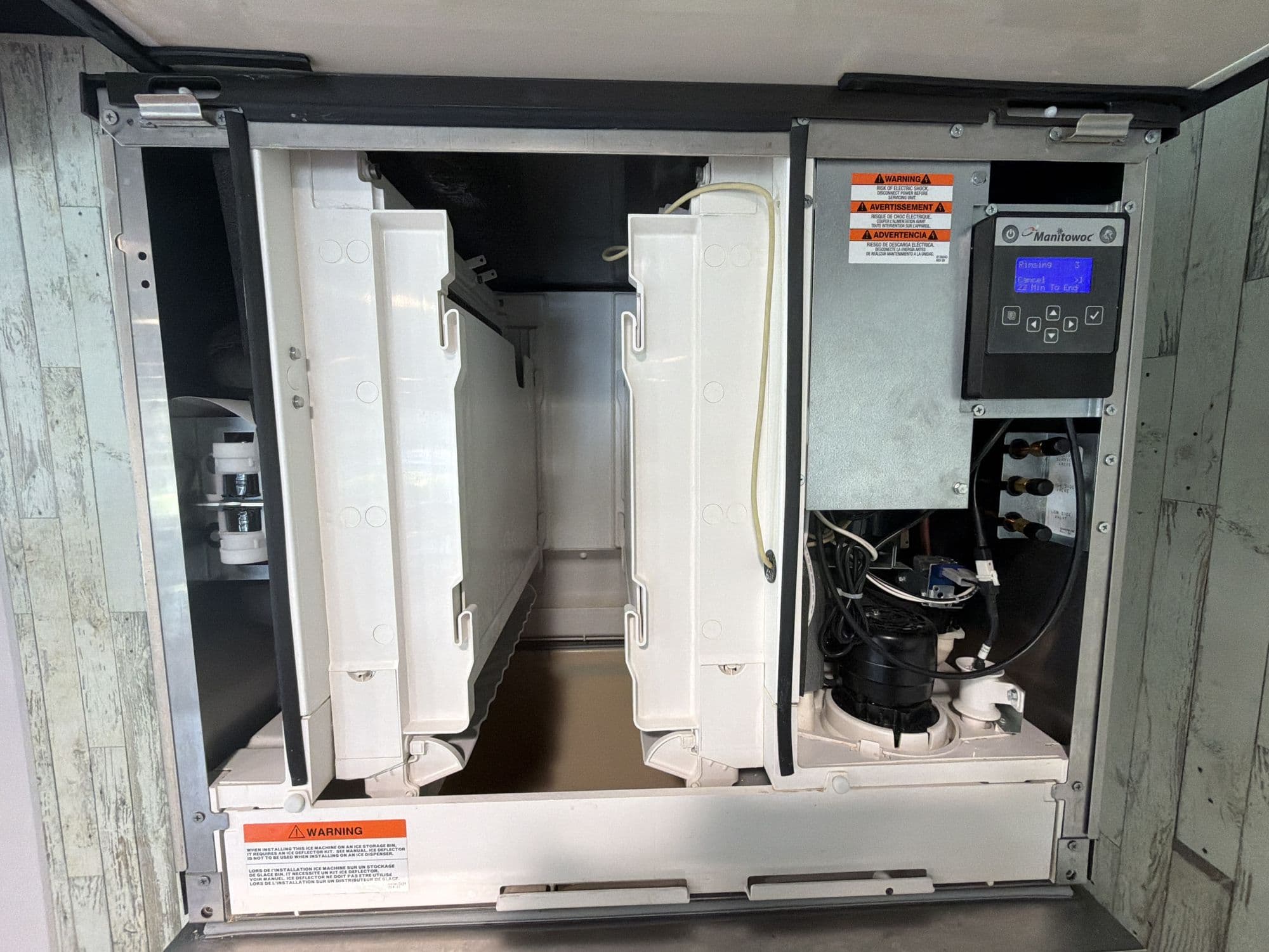 Commercial ice machine opened for service on a restaurant ice bin