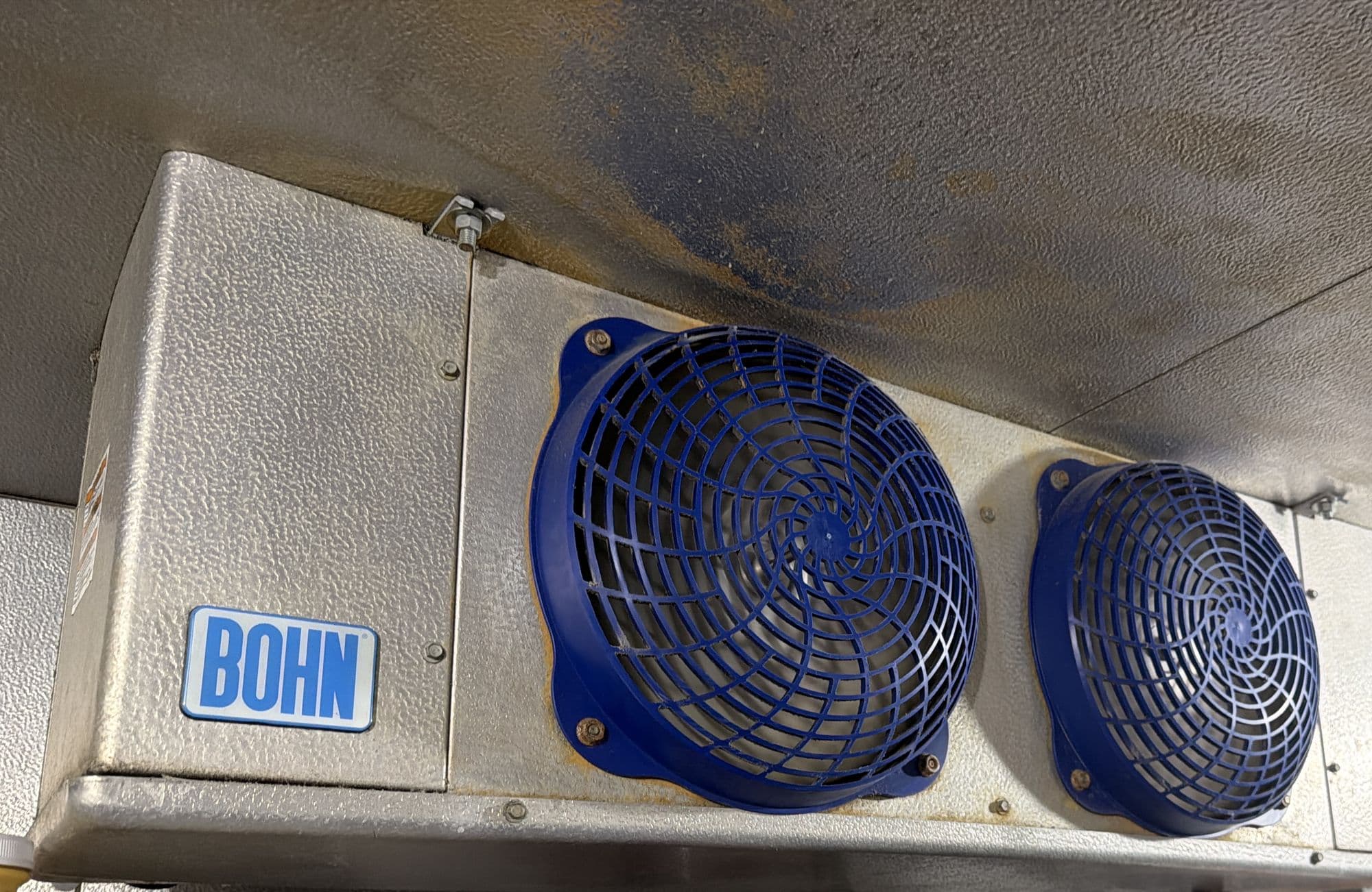 Two-fan evaporator coil mounted on the ceiling of a walk-in cooler