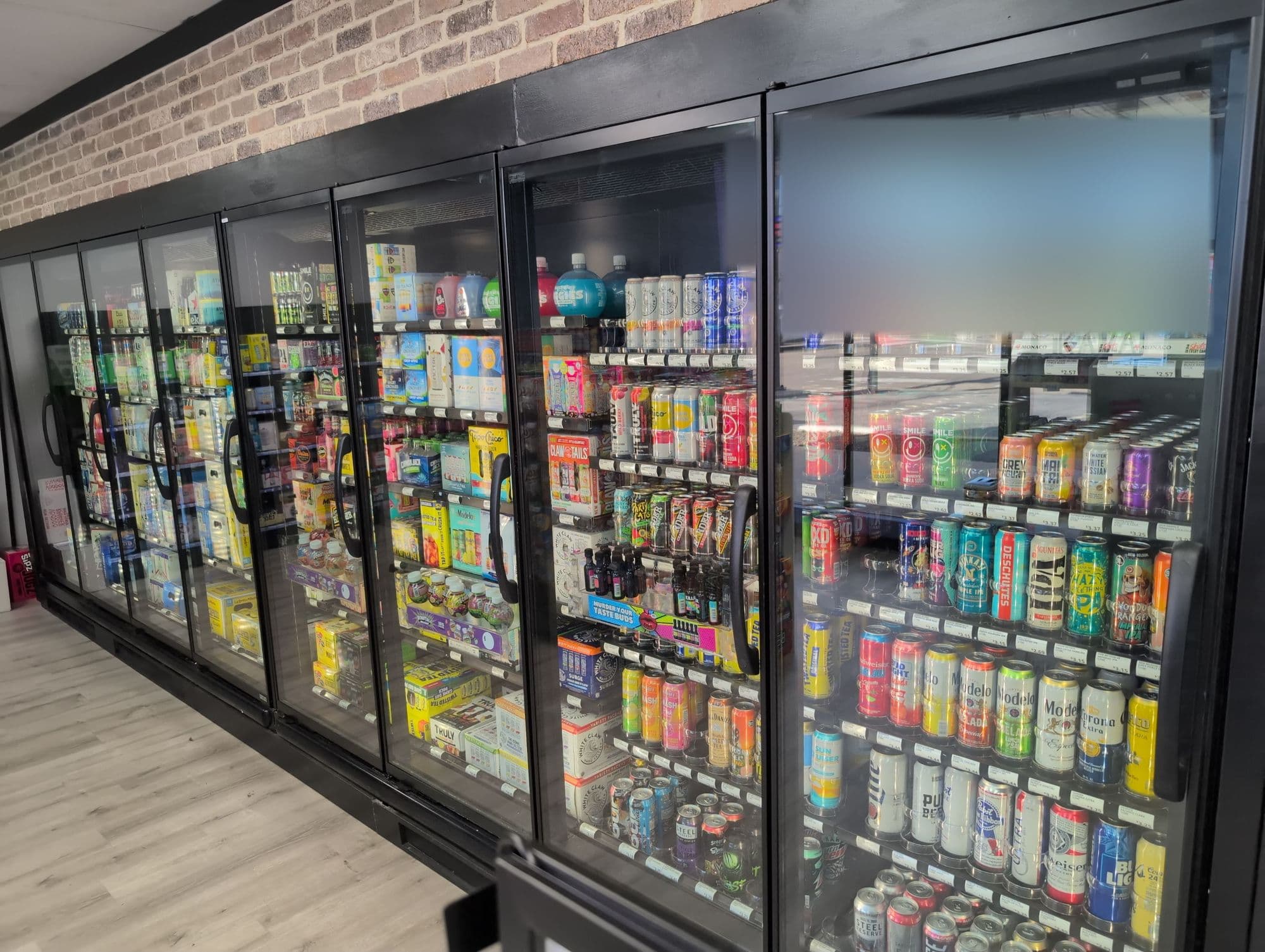 Row of glass-door reach-in beverage coolers in a convenience store