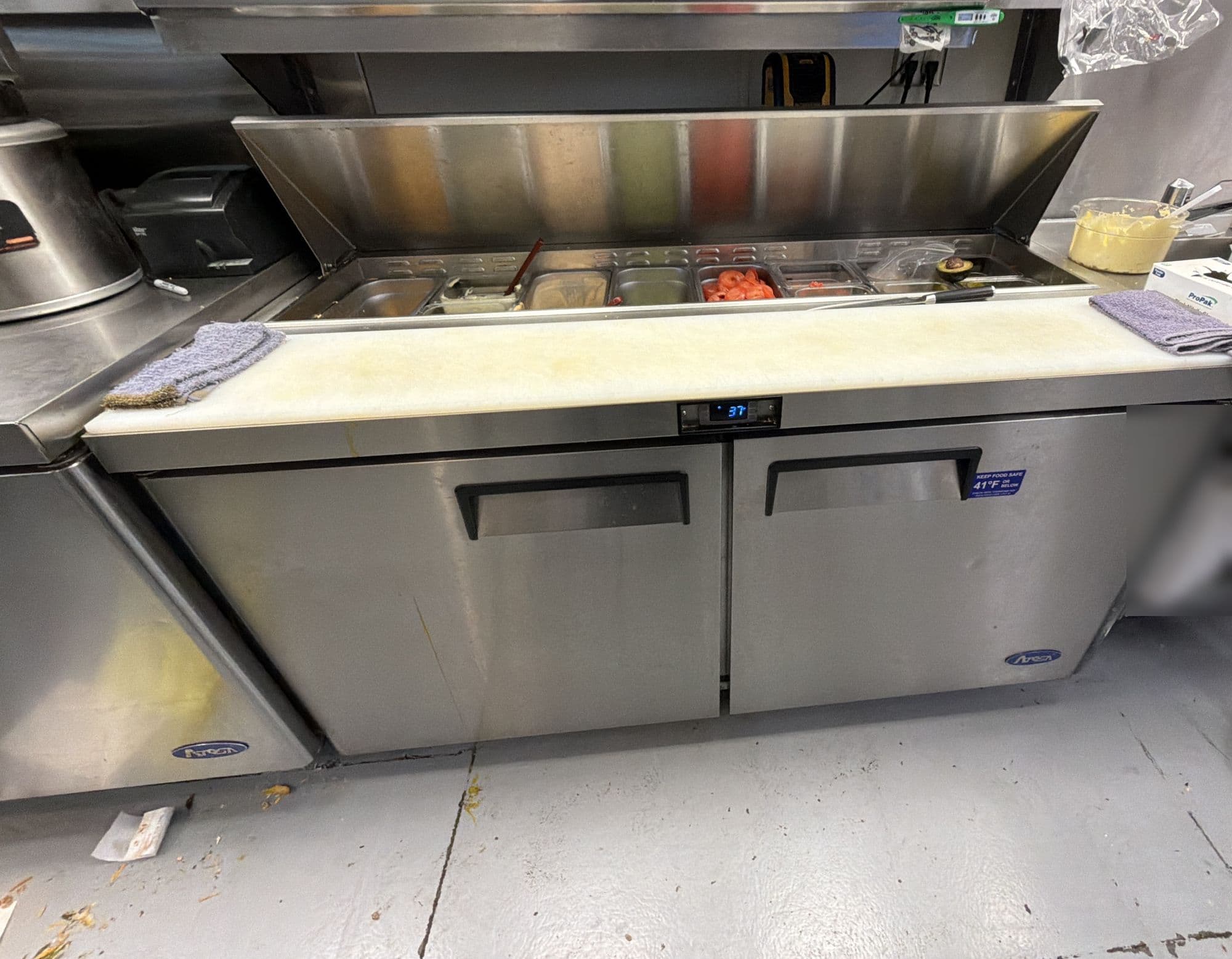 Refrigerated sandwich prep table with the lid open over the food pans and a digital temperature display