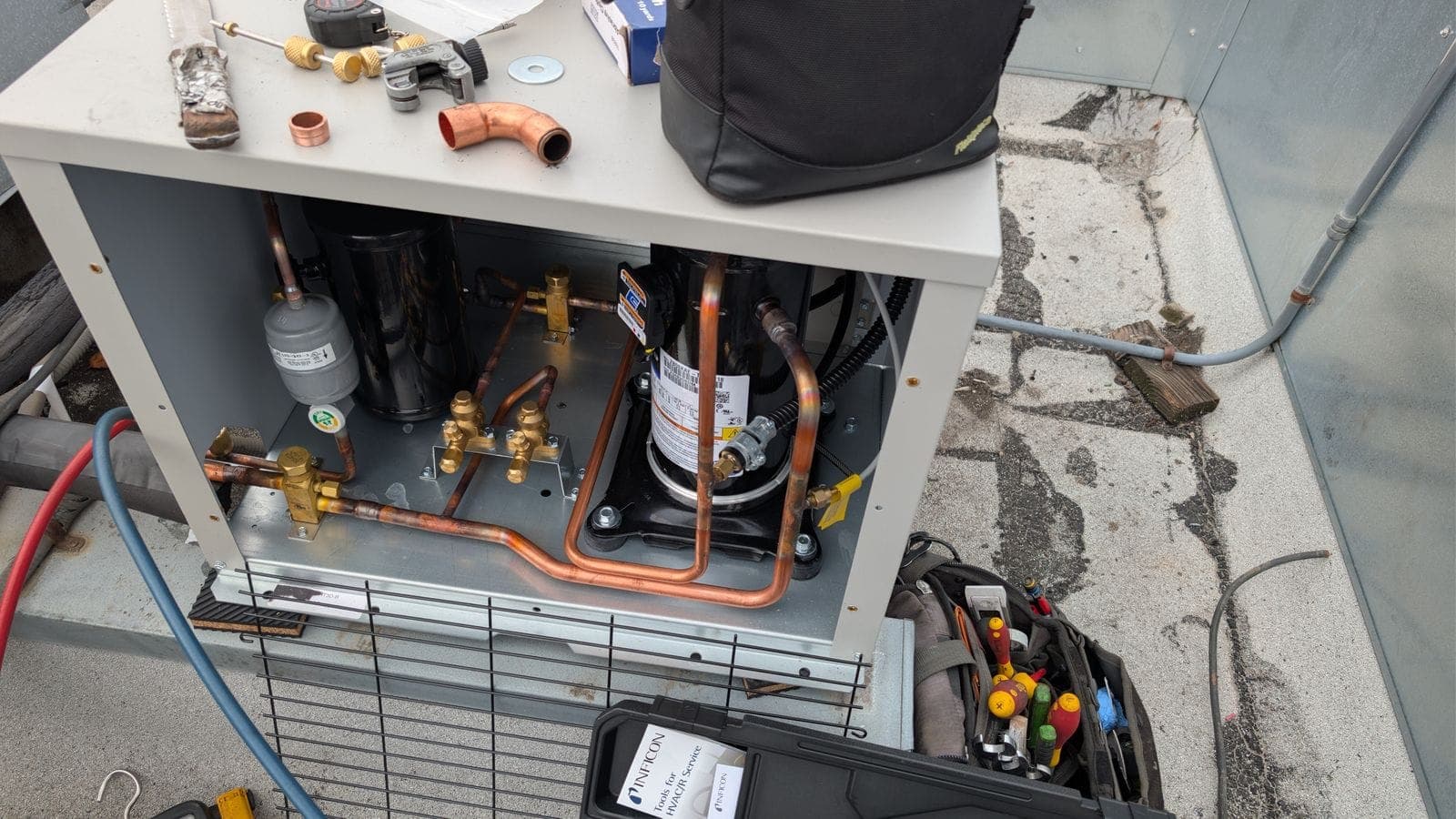 Tools on a walk-in cooler condensing unit during installation