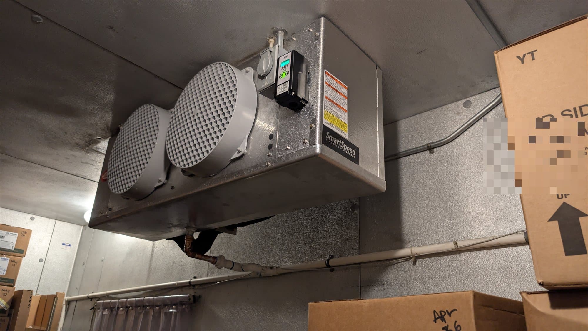 Evaporator coil with dual fans inside a commercial walk-in cooler